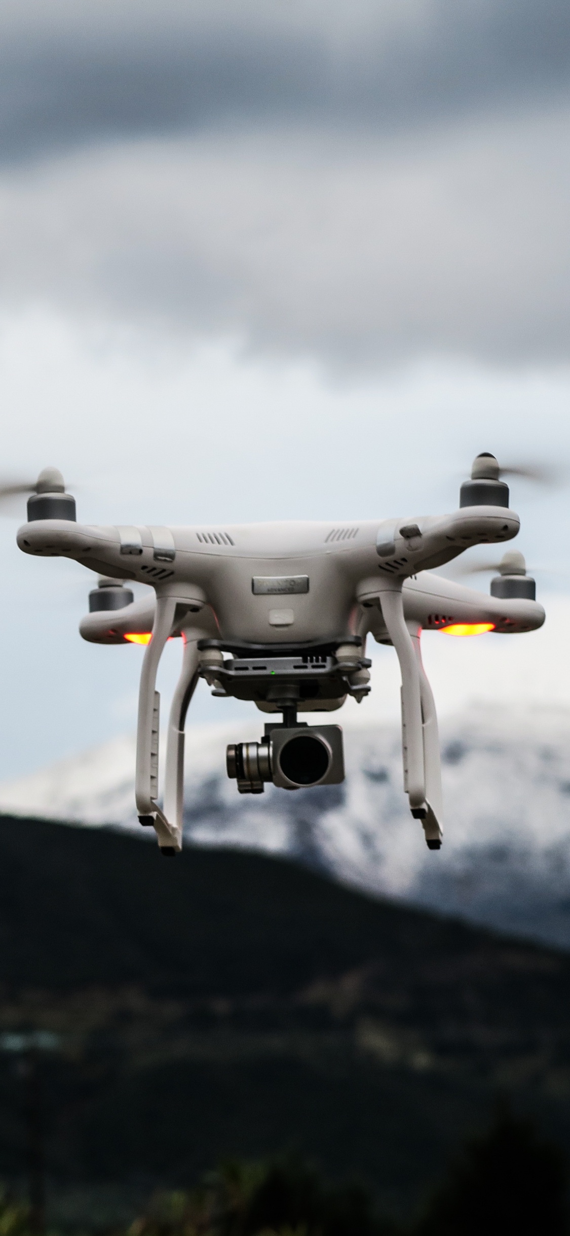 Drone Gris Volando Sobre la Montaña Verde Durante el Día. Wallpaper in 1125x2436 Resolution