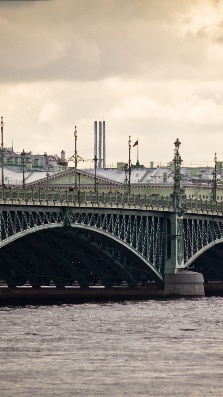 Gray Concrete Bridge Over Body of Water Under Cloudy Sky During Daytime. Wallpaper in 720x1280 Resolution