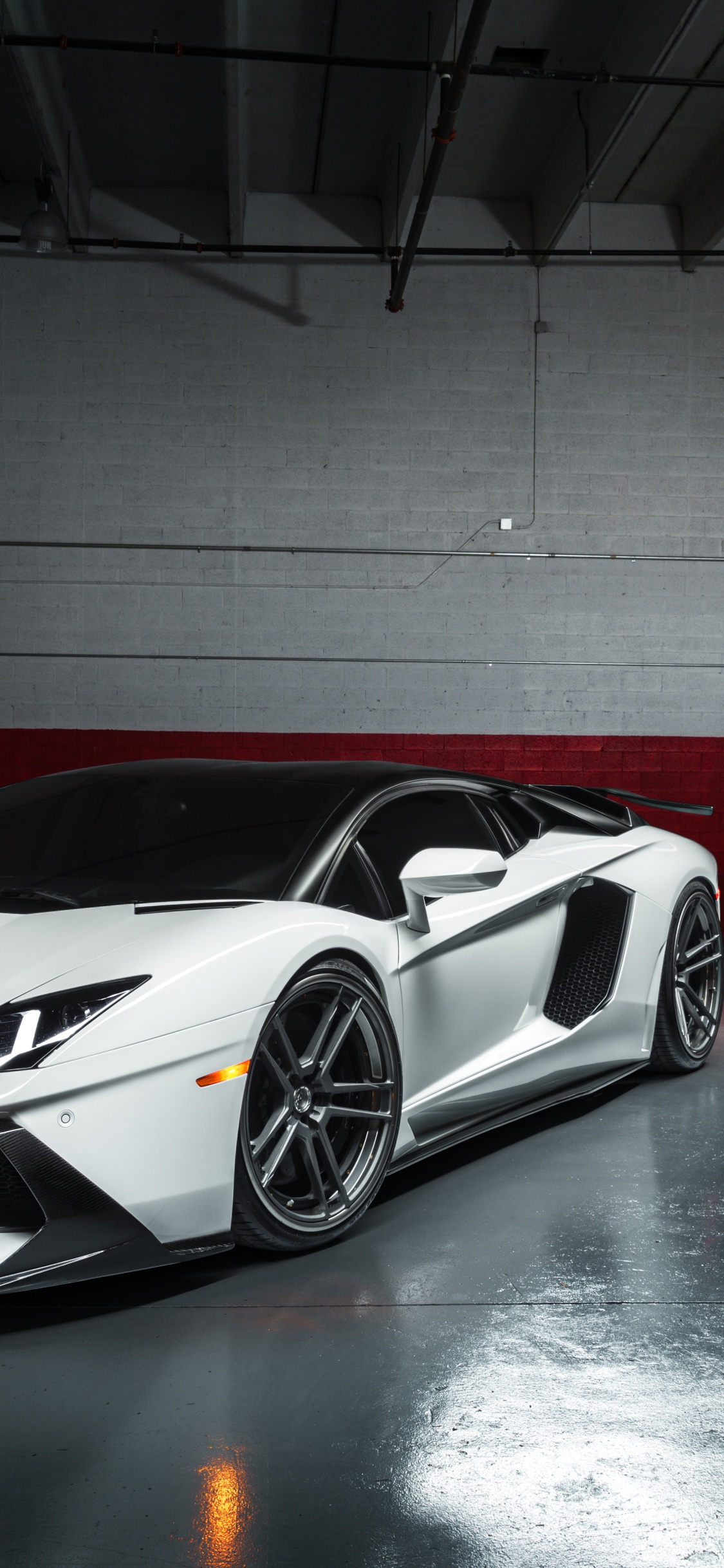 White and Black Porsche 911 Parked in Garage. Wallpaper in 1125x2436 Resolution