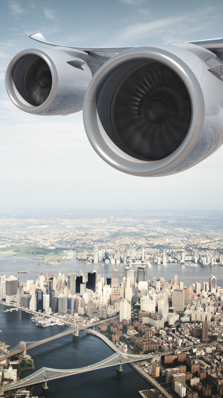 White and Gray Airplane Wing Over City Buildings During Daytime. Wallpaper in 750x1334 Resolution