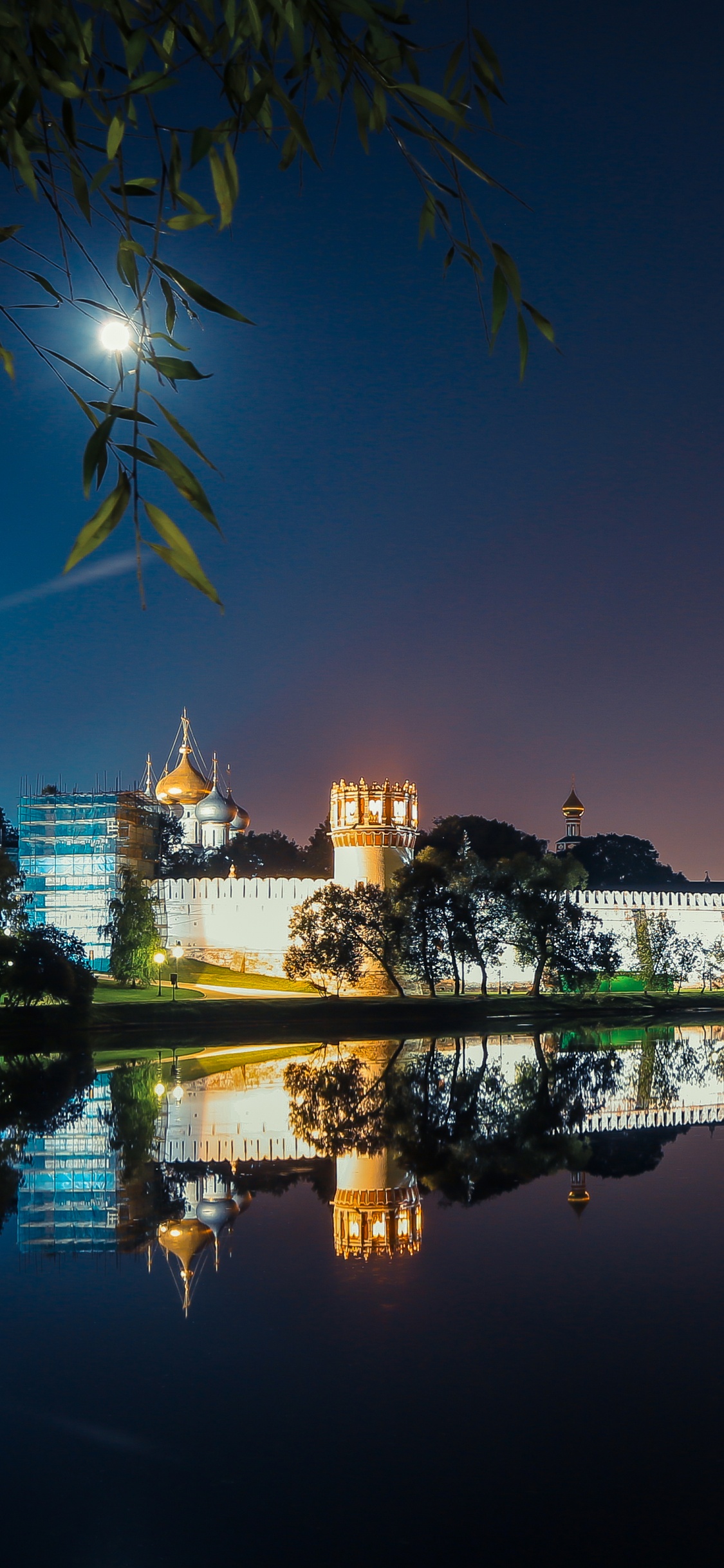 Gewässer in Der Nähe Von Stadtgebäuden Während Der Nacht. Wallpaper in 1125x2436 Resolution
