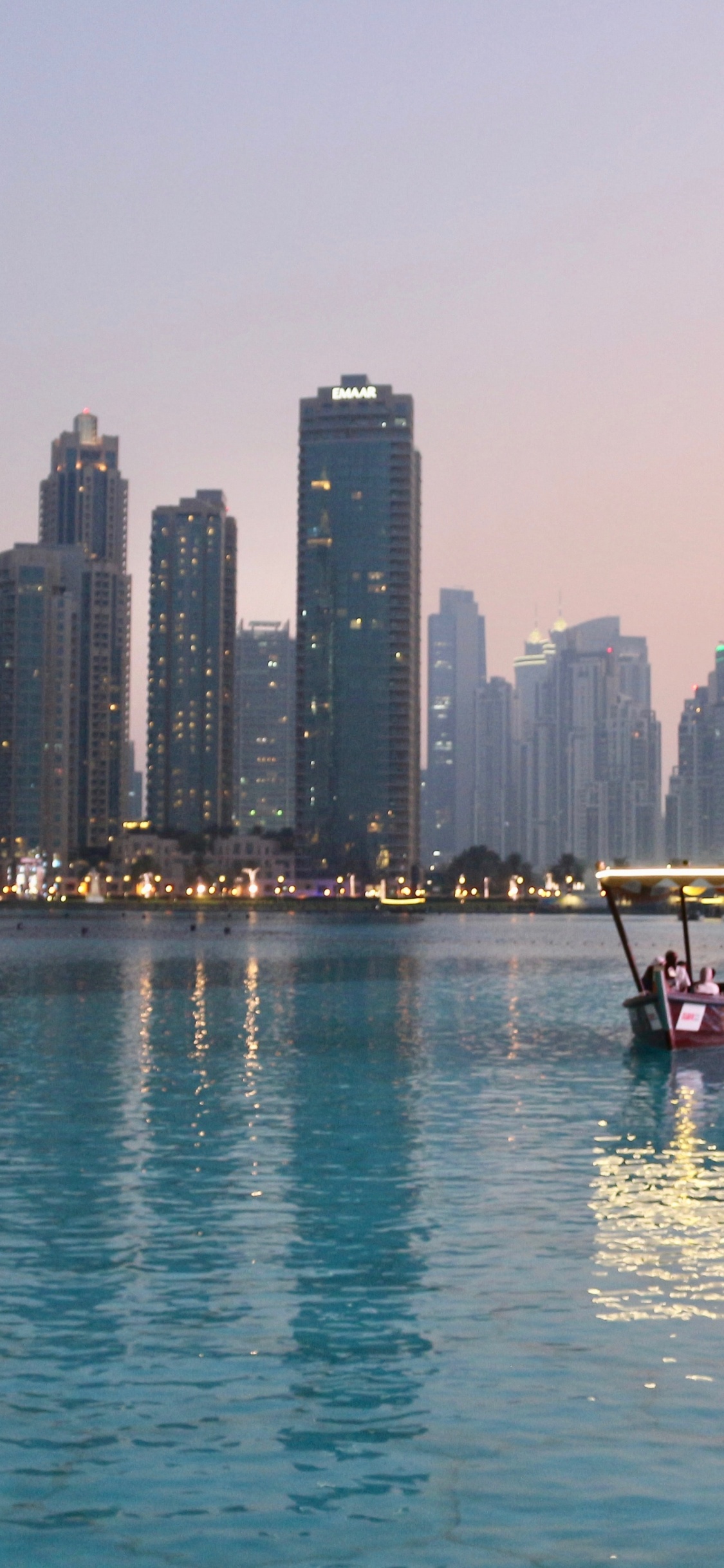 Red Boat on Body of Water Near City Buildings During Daytime. Wallpaper in 1125x2436 Resolution