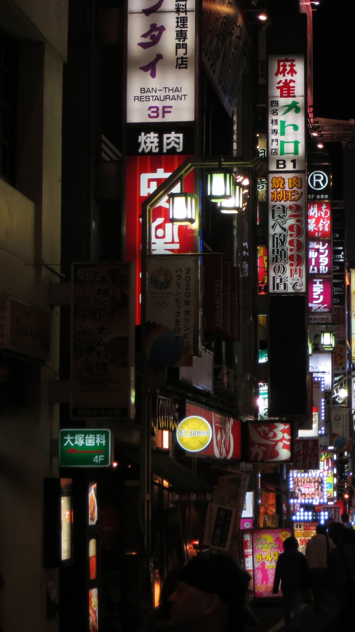 Personnes Marchant Dans la Rue Pendant la Nuit. Wallpaper in 720x1280 Resolution