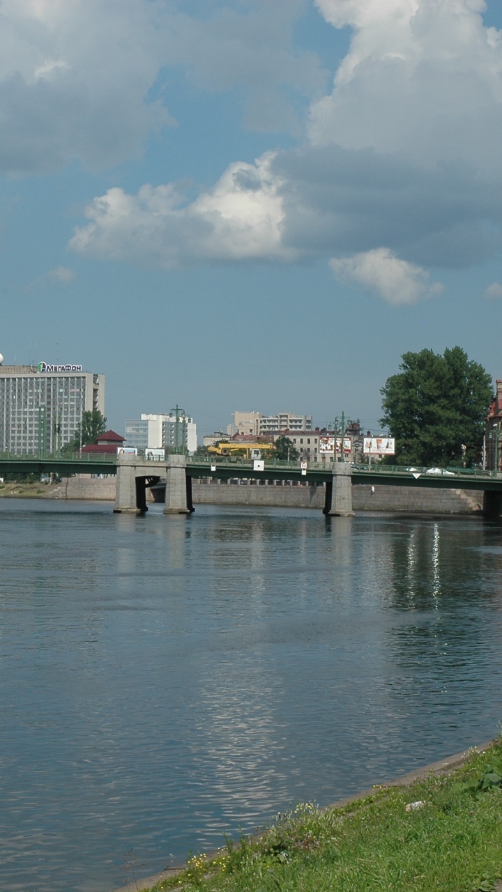 Edificio de Hormigón Blanco Cerca Del Cuerpo de Agua Bajo un Cielo Azul Durante el Día. Wallpaper in 720x1280 Resolution