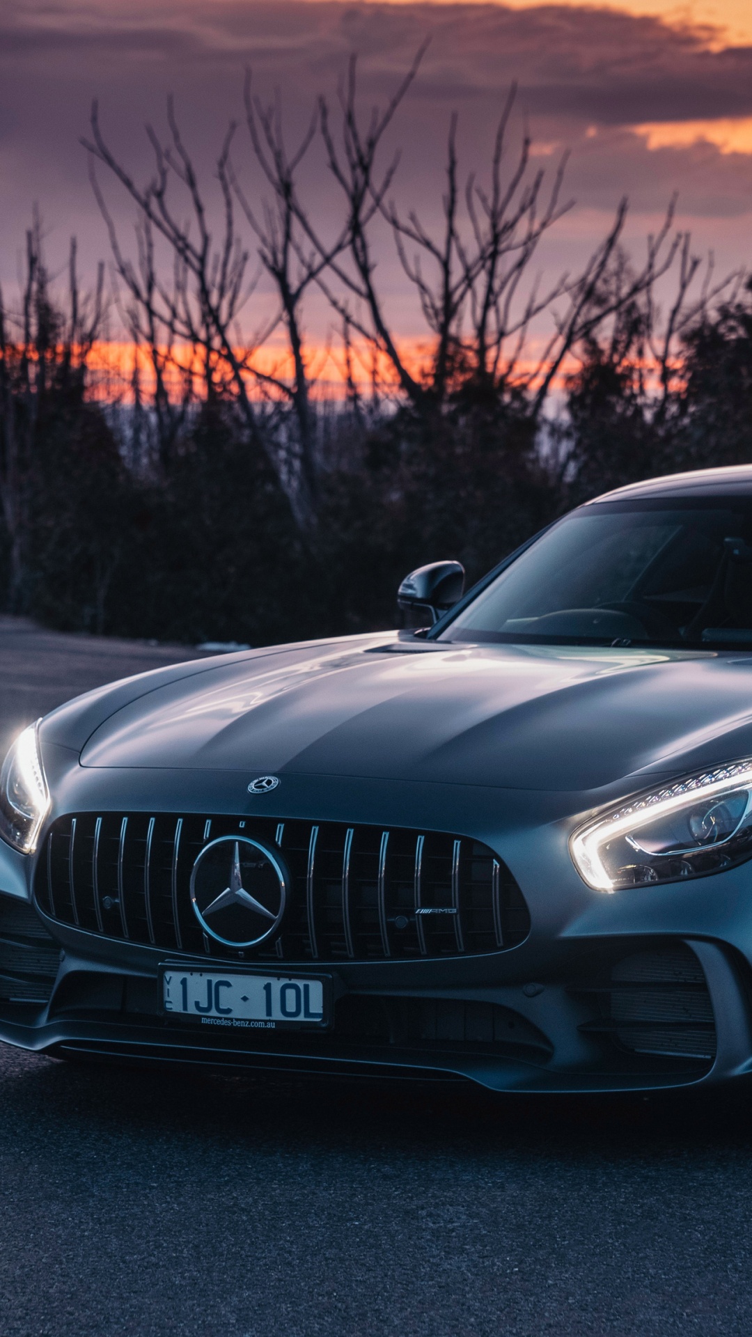 Schwarzes Mercedes-benz-coupé Unterwegs Bei Sonnenuntergang. Wallpaper in 1080x1920 Resolution