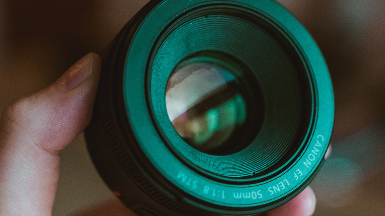 Person Holding Black Camera Lens. Wallpaper in 1280x720 Resolution