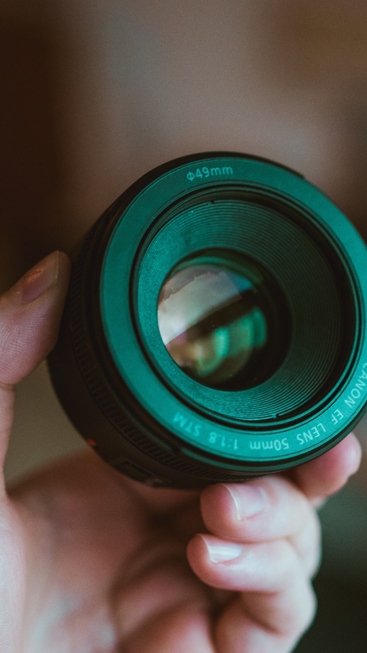 Person Holding Black Camera Lens. Wallpaper in 720x1280 Resolution