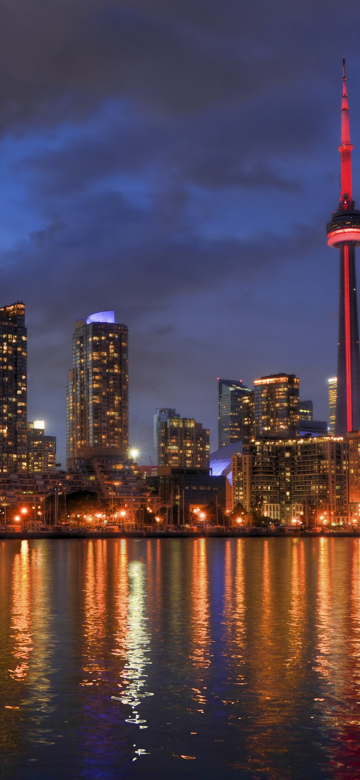 City Skyline Across Body of Water During Night Time. Wallpaper in 1242x2688 Resolution