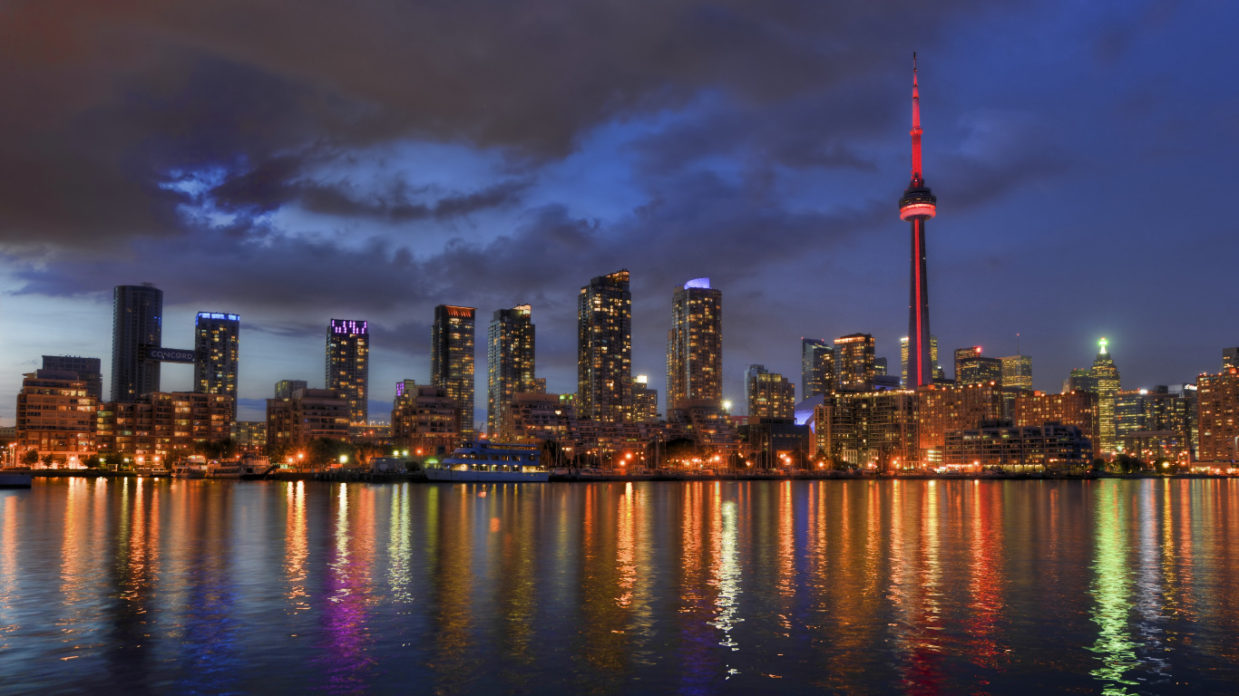 Skyline Der Stadt Über Gewässer Während Der Nacht. Wallpaper in 1366x768 Resolution