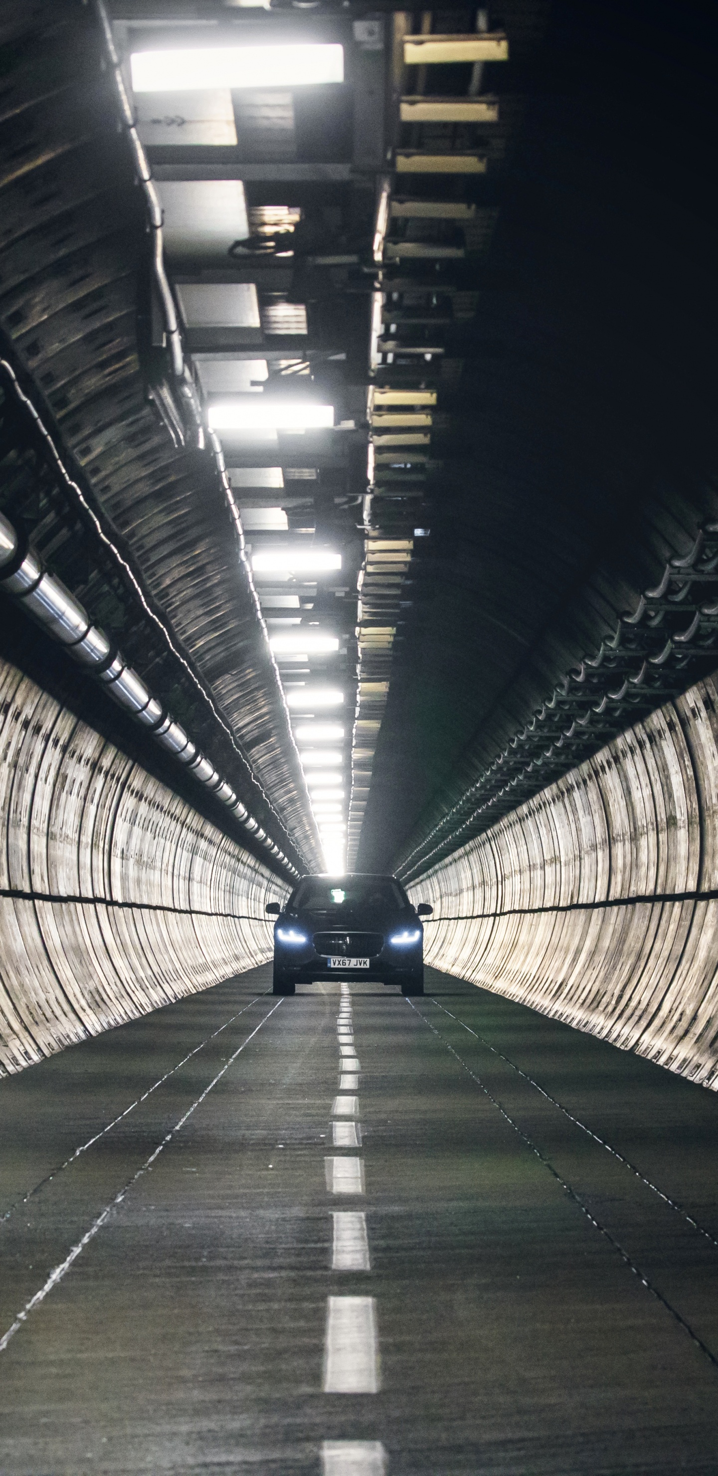 Man in Black Jacket Walking on Tunnel. Wallpaper in 1440x2960 Resolution