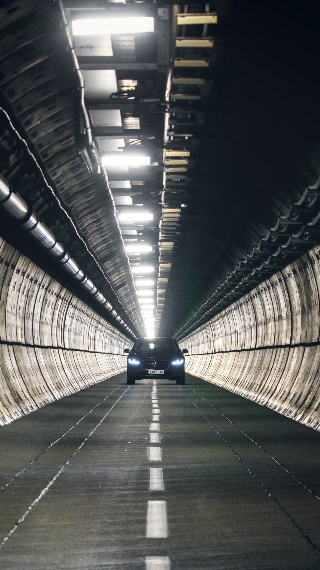 Homme en Veste Noire Marchant Sur Tunnel. Wallpaper in 1080x1920 Resolution