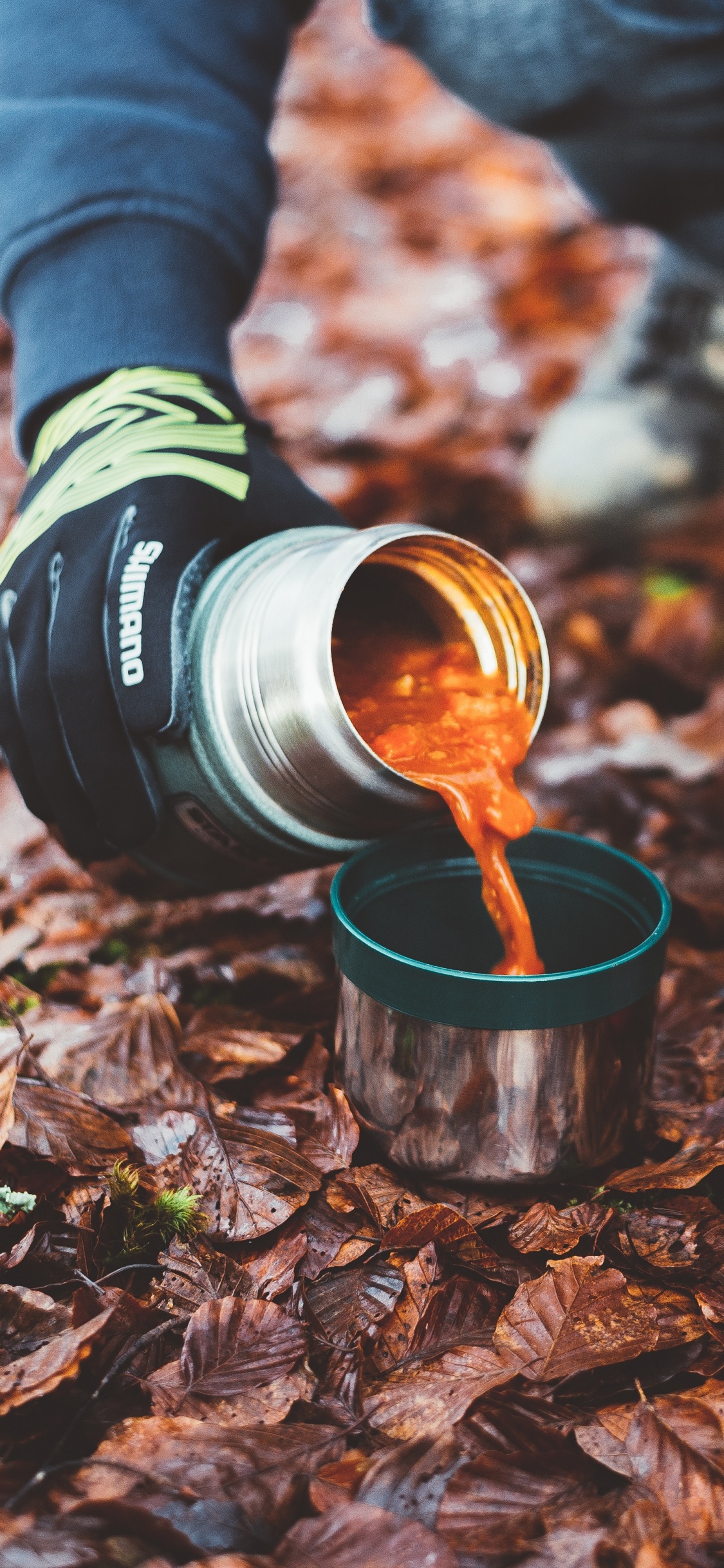 Person Mit Rotem Und Schwarzem Kameraobjektiv. Wallpaper in 1125x2436 Resolution