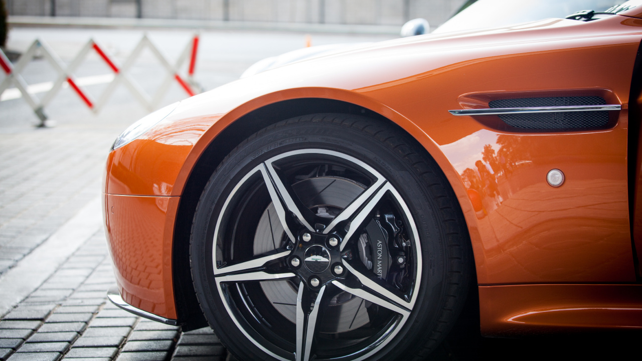 Orange and Black Car on Gray Pavement. Wallpaper in 1280x720 Resolution