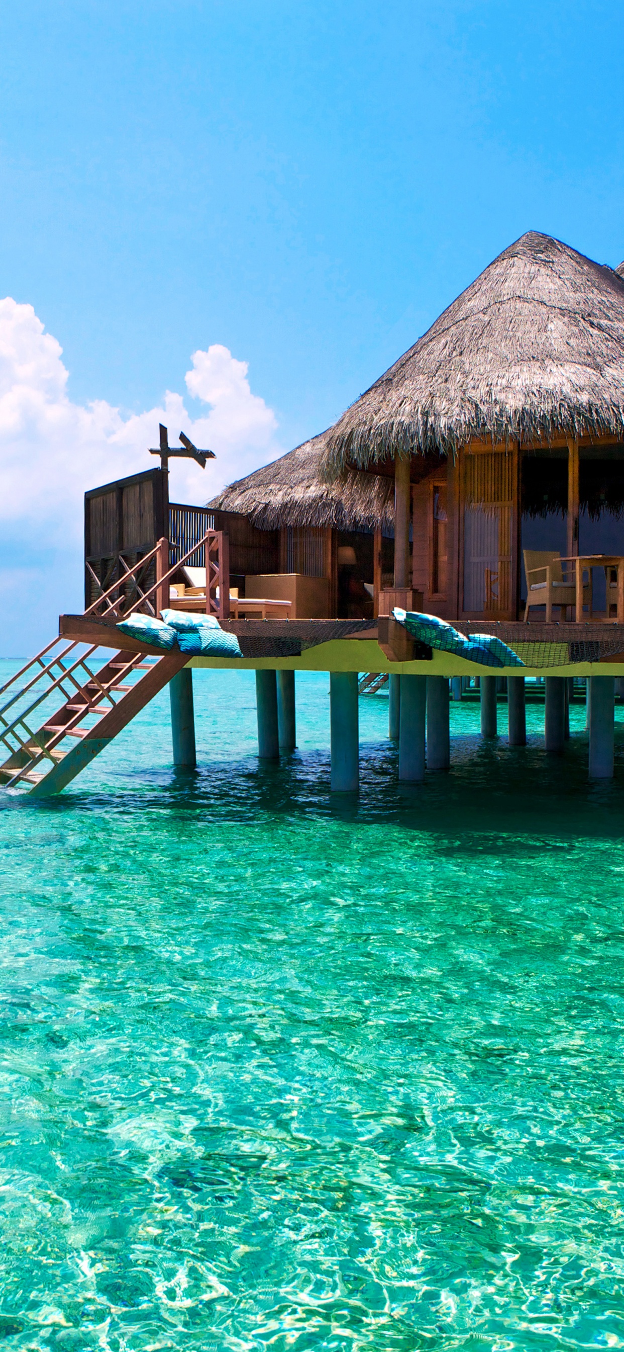 Brown Wooden Beach House on Blue Sea Under Blue Sky During Daytime. Wallpaper in 1242x2688 Resolution