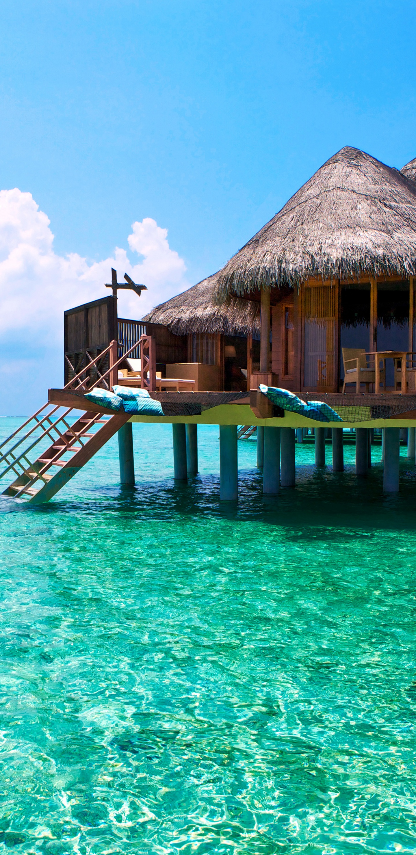 Brown Wooden Beach House on Blue Sea Under Blue Sky During Daytime. Wallpaper in 1440x2960 Resolution