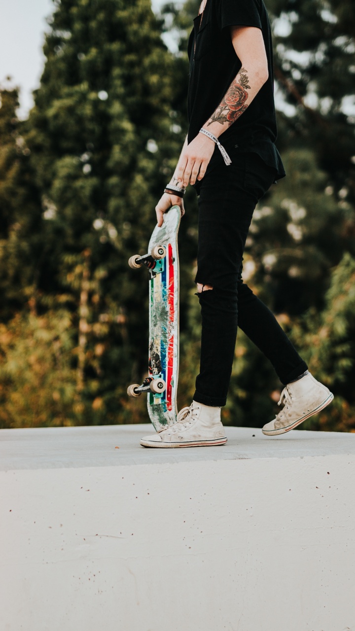Mann in Schwarzer Hose Und Schwarzer Jacke, Der Skateboard Fährt. Wallpaper in 720x1280 Resolution