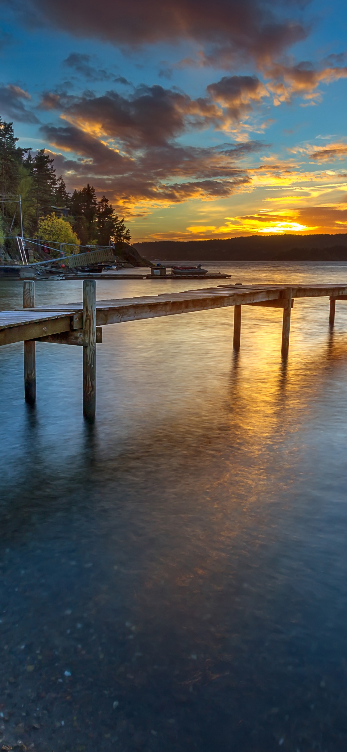 Braunes Holzdock am Gewässer Tagsüber. Wallpaper in 1125x2436 Resolution