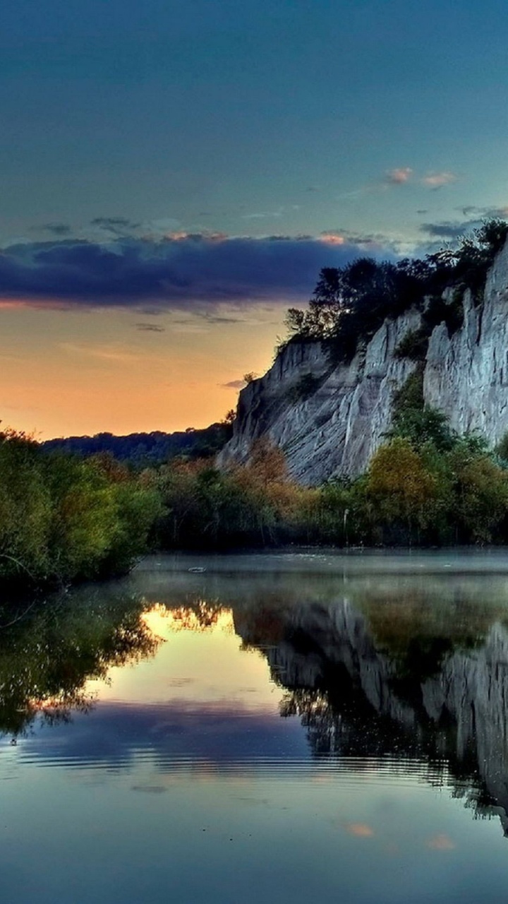Gray Rocky Mountain Beside Body of Water During Daytime. Wallpaper in 720x1280 Resolution