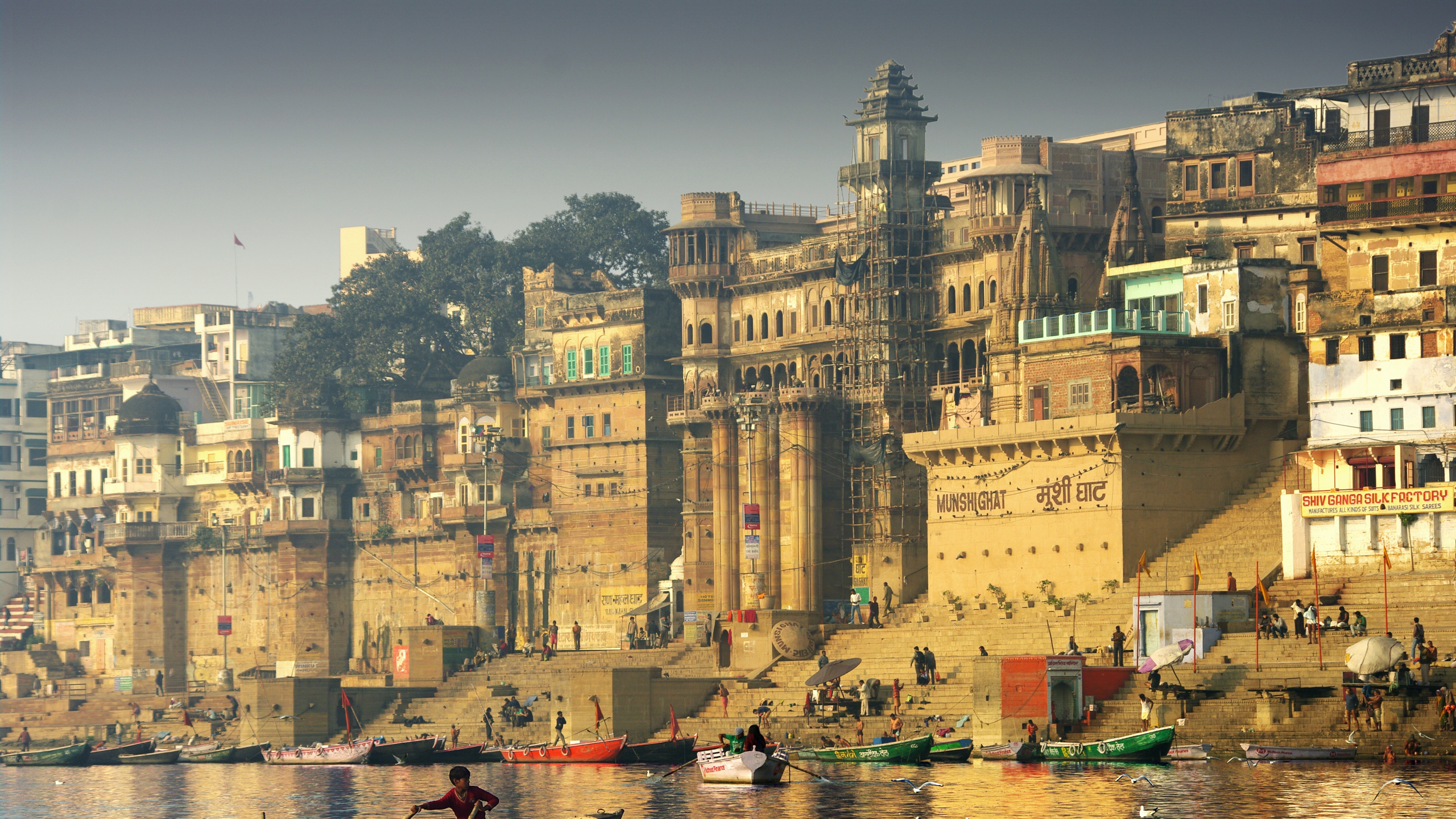 Brown Concrete Building Near Body of Water During Daytime. Wallpaper in 2560x1440 Resolution