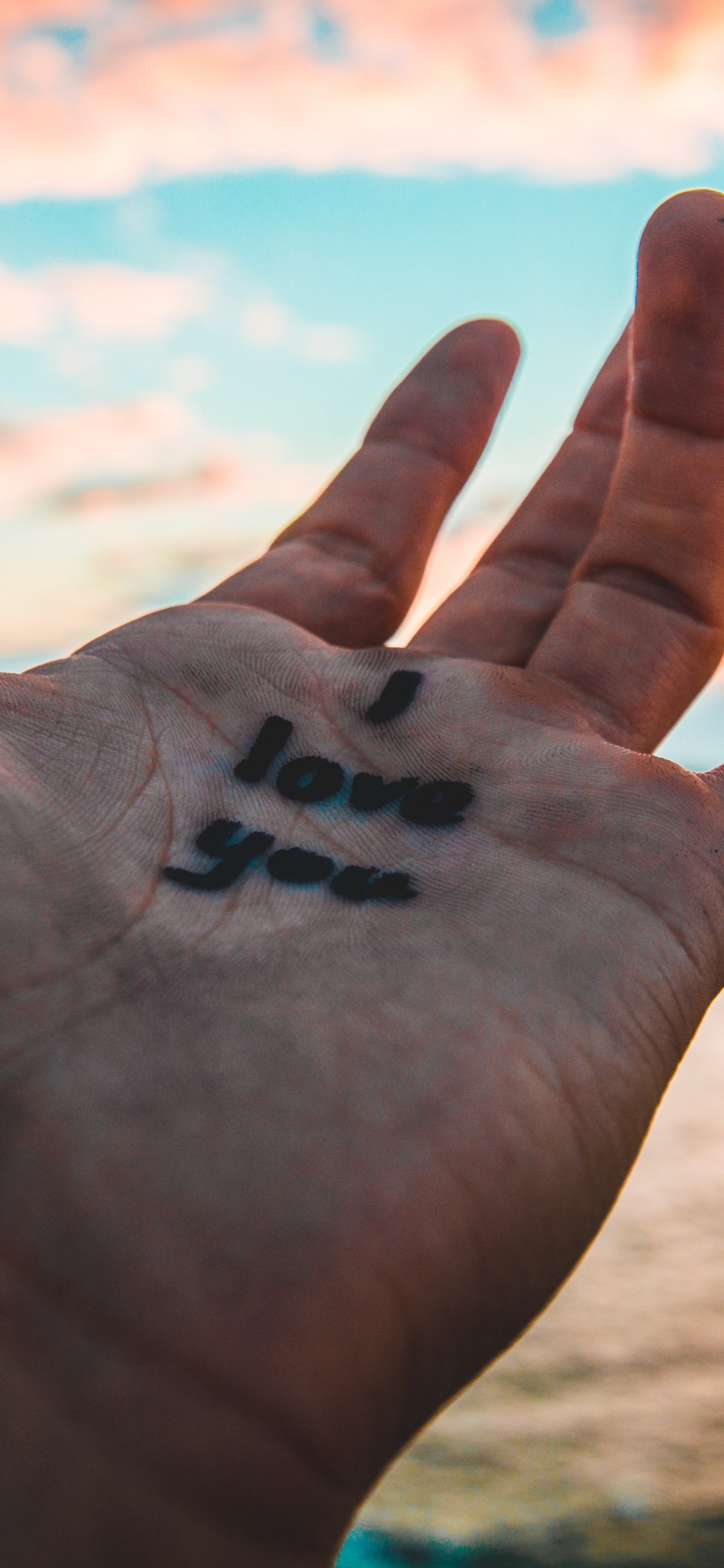 Black Heart Shaped on Persons Hand. Wallpaper in 1242x2688 Resolution