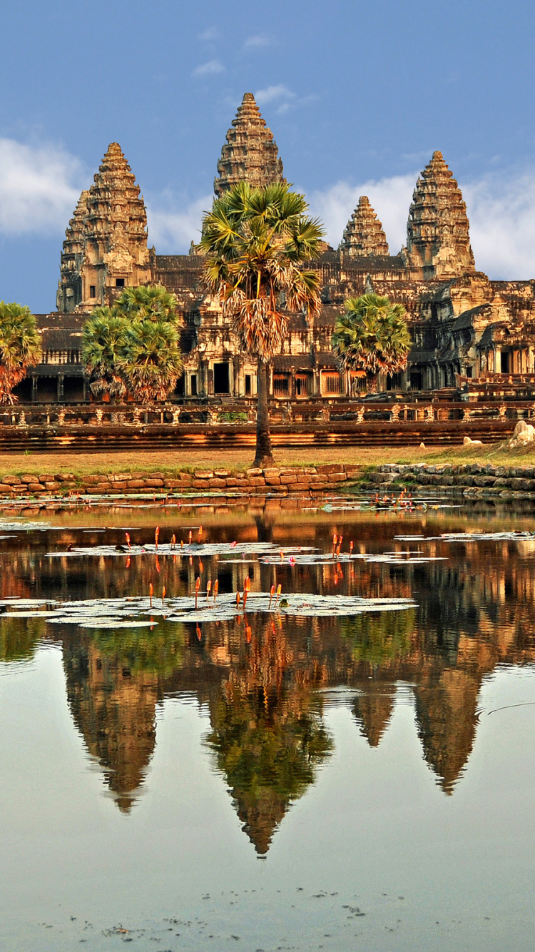 Brown Concrete Building Near Body of Water During Daytime. Wallpaper in 750x1334 Resolution