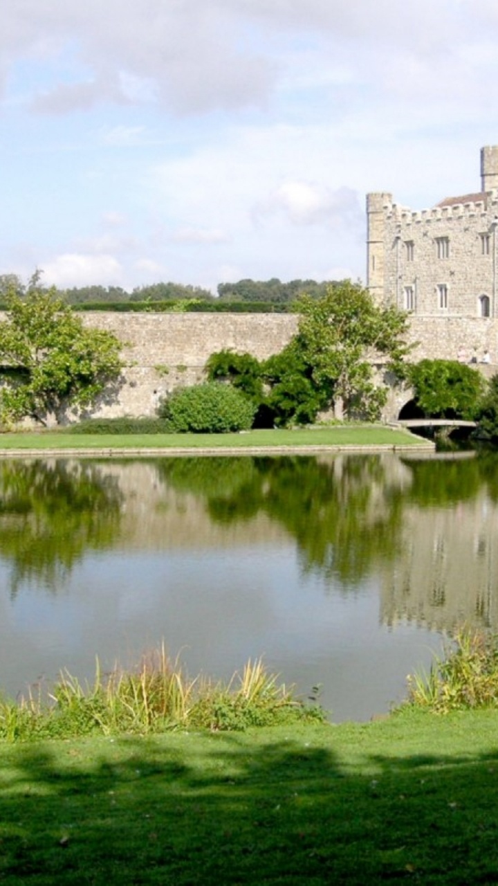 Bâtiment en Béton Gris Près du Champ D'herbe Verte et du Lac Sous Les Nuages Blancs et le Ciel Bleu Pendant. Wallpaper in 720x1280 Resolution