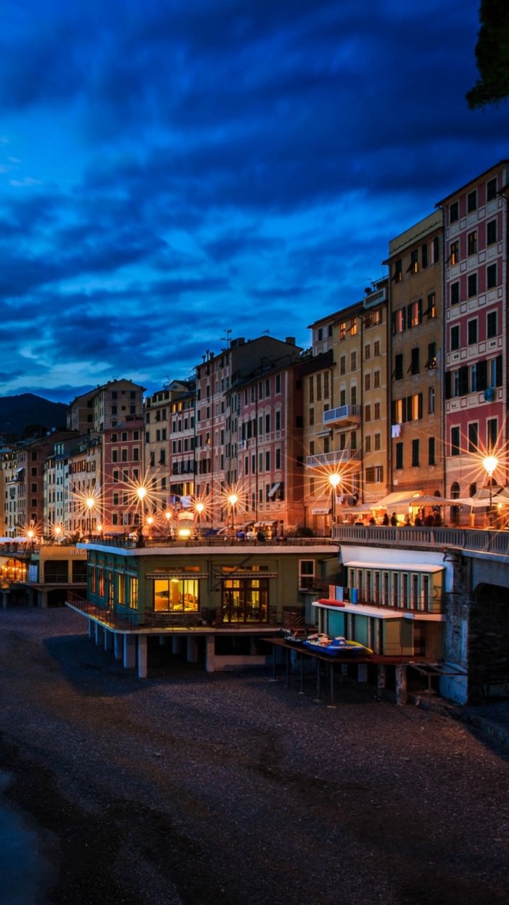 Skyline Der Stadt in Der Nähe Von Gewässern Während Der Nacht. Wallpaper in 720x1280 Resolution