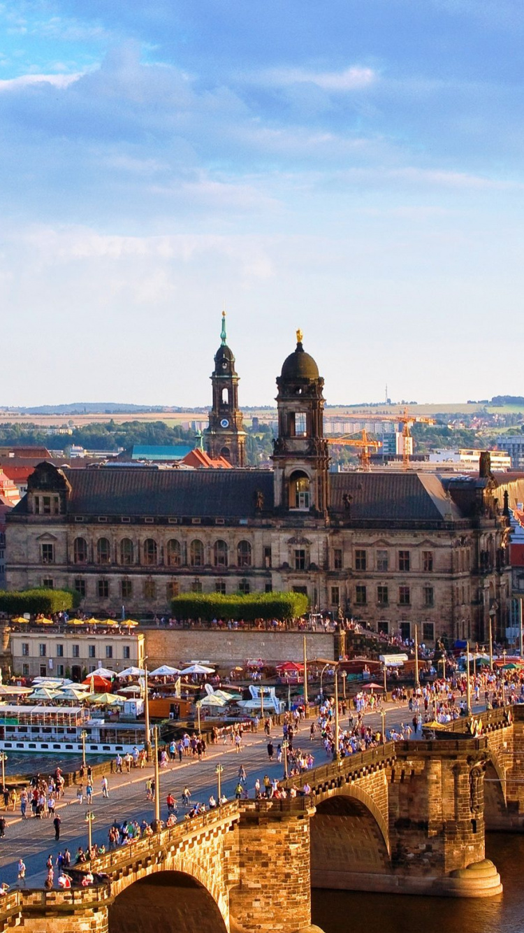 Brown Concrete Building Near Body of Water During Daytime. Wallpaper in 750x1334 Resolution