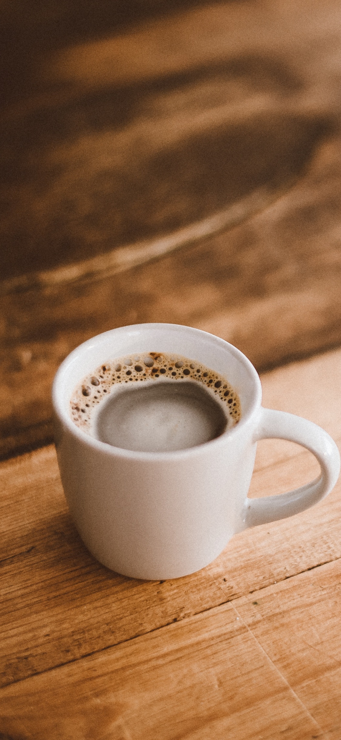 White Ceramic Mug on Brown Wooden Table. Wallpaper in 1125x2436 Resolution