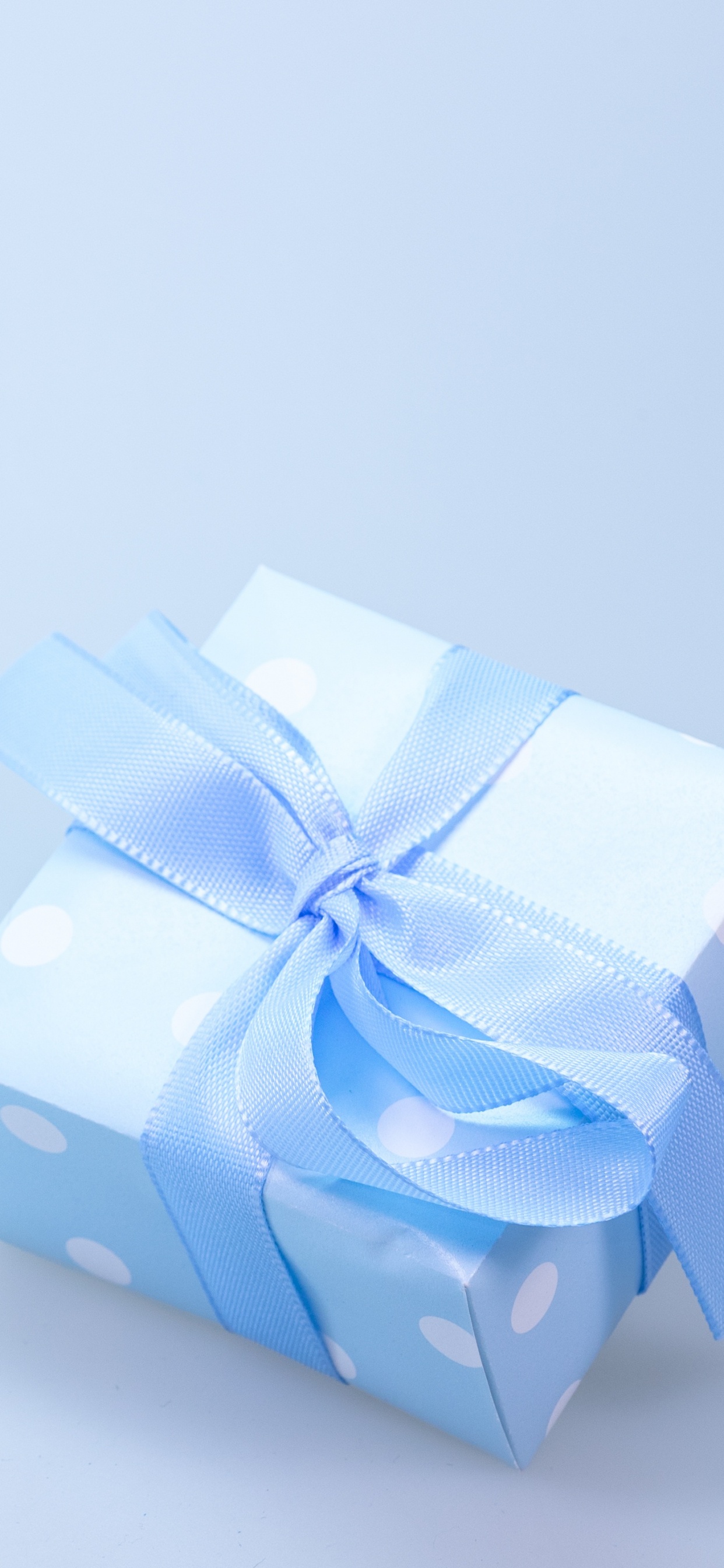 Blue and White Polka Dot Gift Box With White Ribbon. Wallpaper in 1242x2688 Resolution