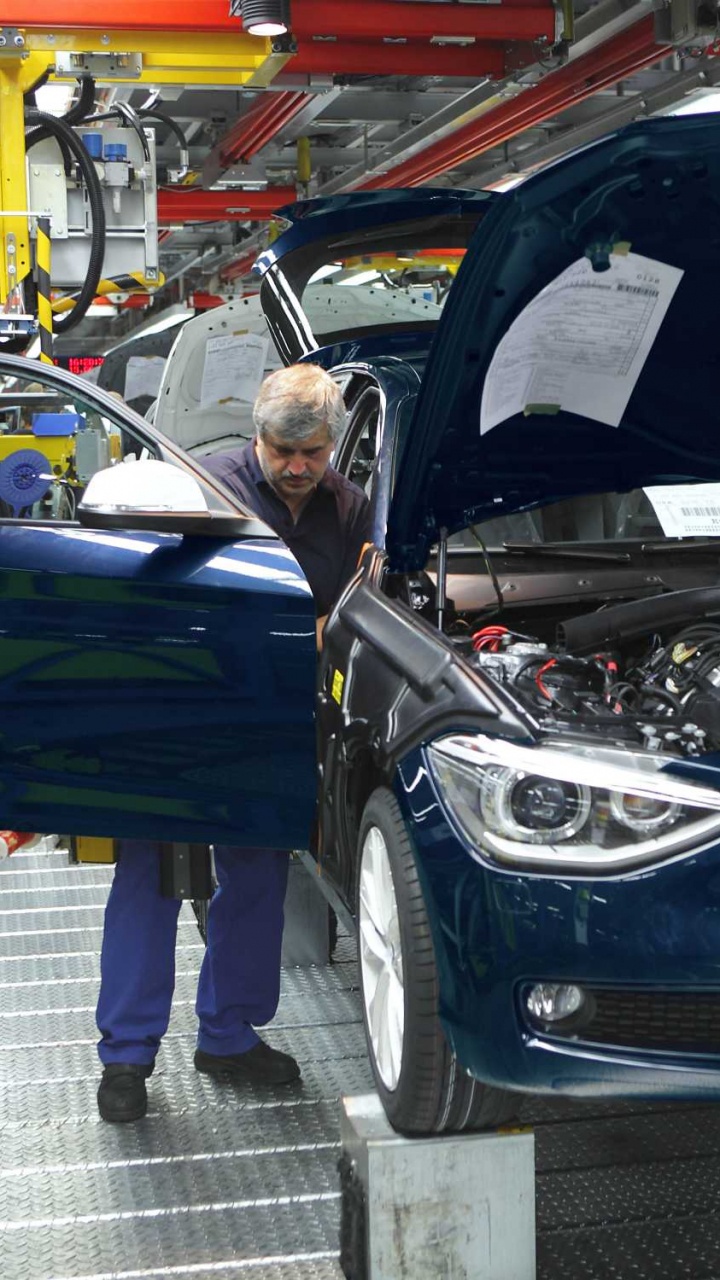 Frau im Blauen Ärmellosen Kleid Neben Schwarzem BMW-Auto. Wallpaper in 720x1280 Resolution