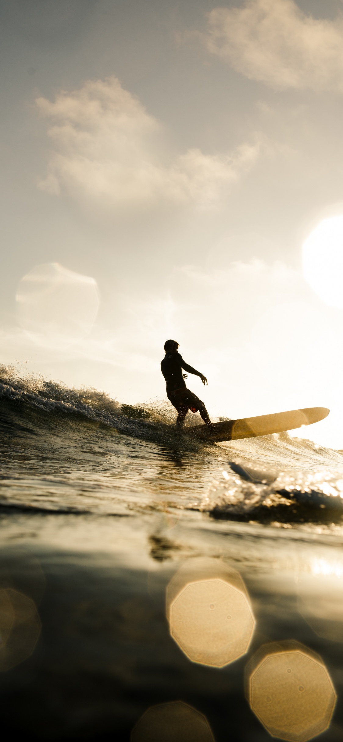 Silhouette Eines Mannes, Der Tagsüber Ein Surfbrett Auf Dem Wasser Hält. Wallpaper in 1125x2436 Resolution