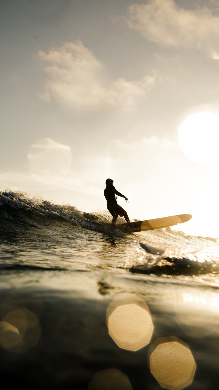 Silhouette Eines Mannes, Der Tagsüber Ein Surfbrett Auf Dem Wasser Hält. Wallpaper in 720x1280 Resolution