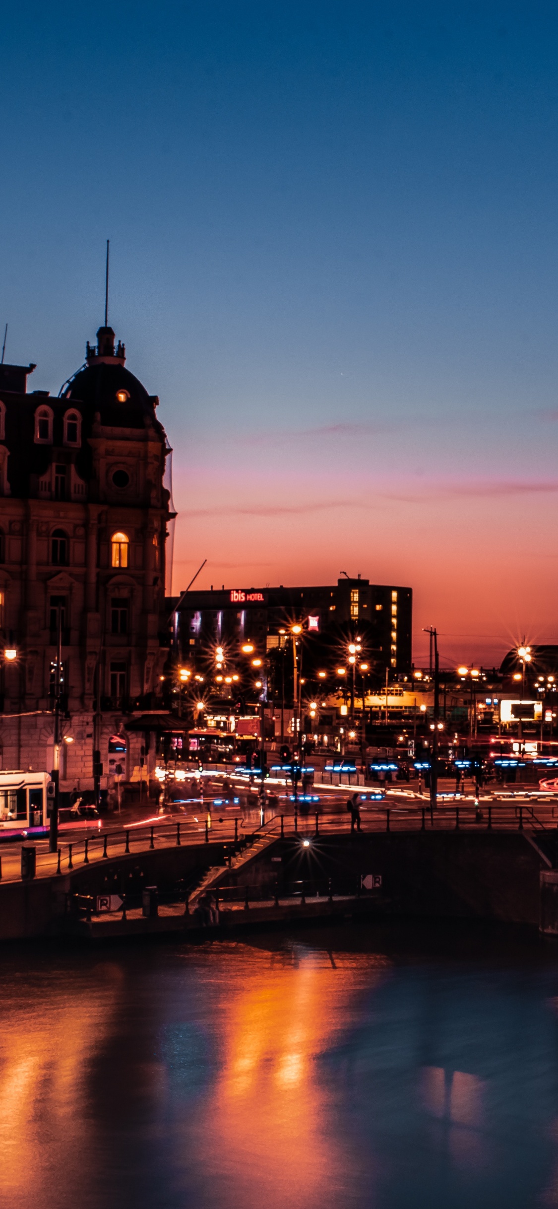 Braunes Betongebäude in Der Nähe Des Flusses Während Der Nachtzeit. Wallpaper in 1125x2436 Resolution