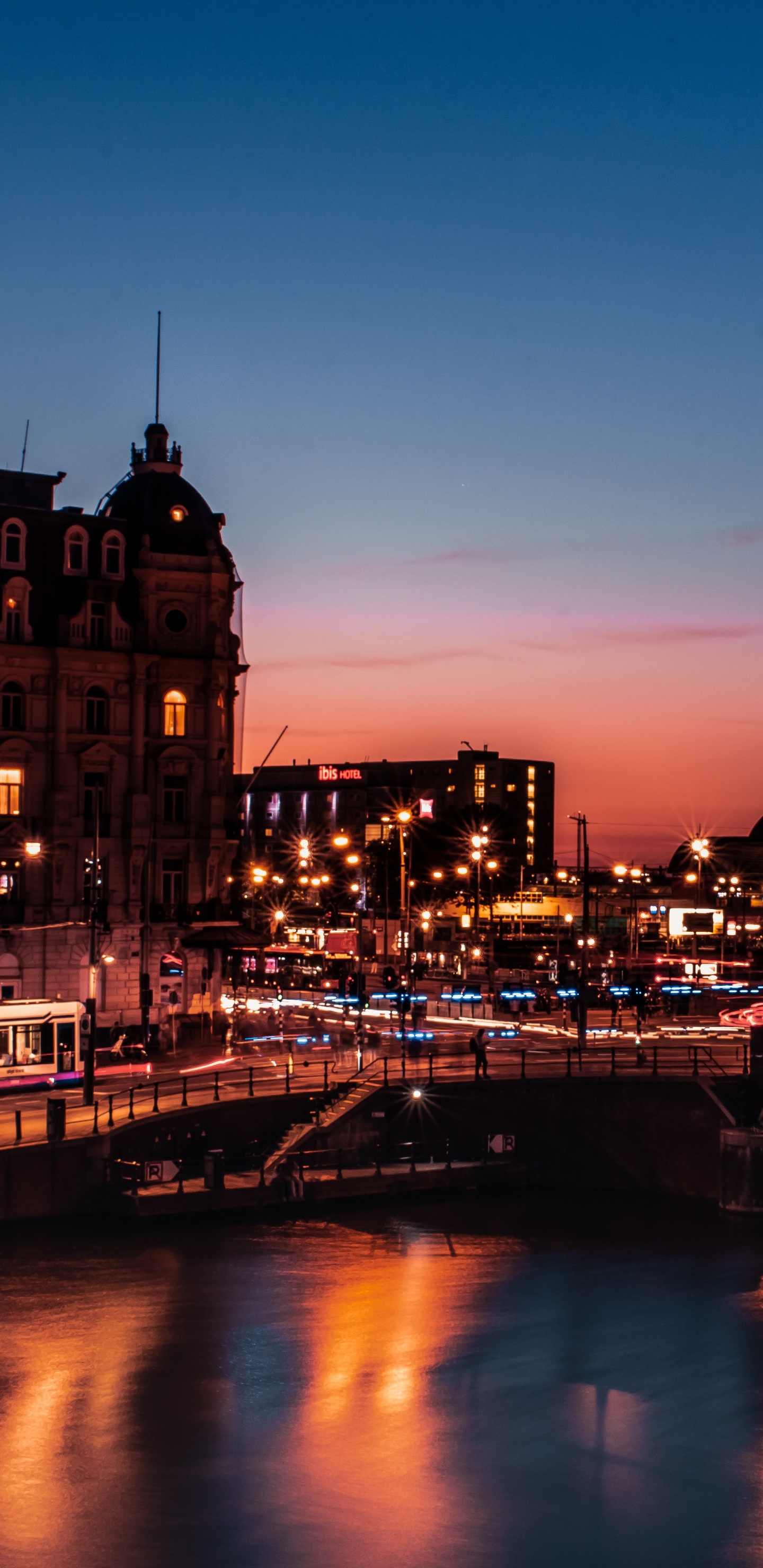 Braunes Betongebäude in Der Nähe Des Flusses Während Der Nachtzeit. Wallpaper in 1440x2960 Resolution