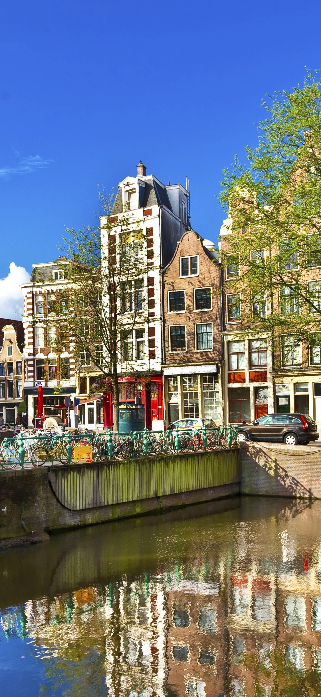 Personnes Marchant Sur le Pont Au-dessus de la Rivière Pendant la Journée. Wallpaper in 1125x2436 Resolution