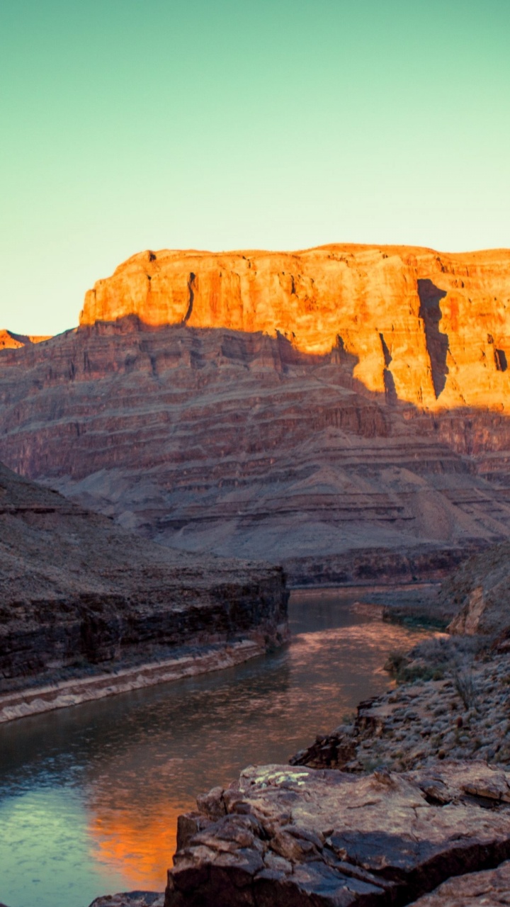 Montaña Rocosa Marrón Junto al Cuerpo de Agua Durante el Día. Wallpaper in 720x1280 Resolution