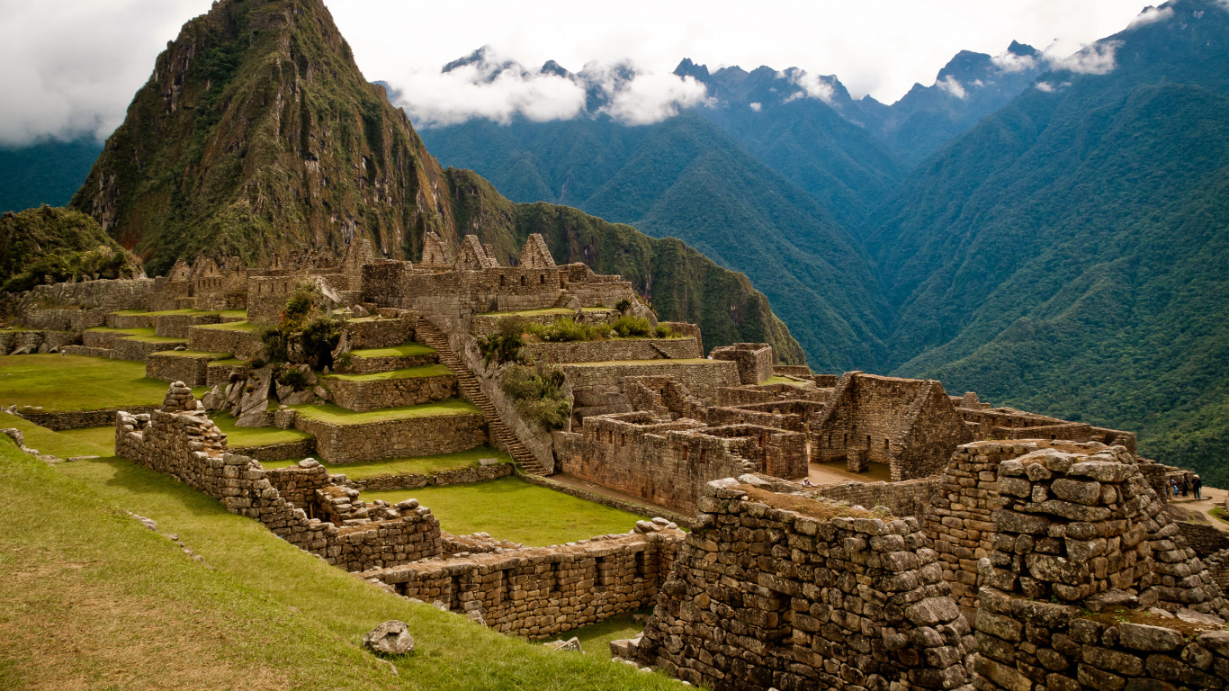 Edificio de Hormigón Marrón en el Campo de Hierba Verde Cerca de la Montaña Bajo Nubes Blancas Durante el Día. Wallpaper in 1366x768 Resolution