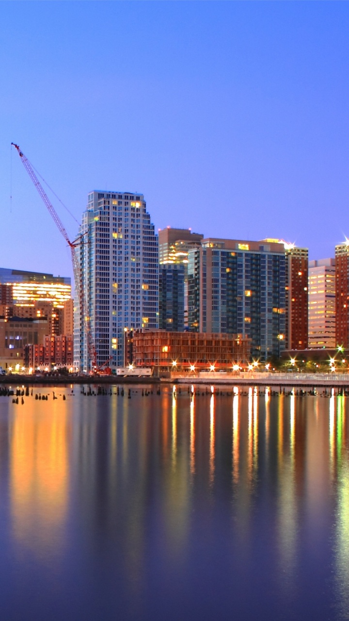City Skyline Across Body of Water During Night Time. Wallpaper in 720x1280 Resolution