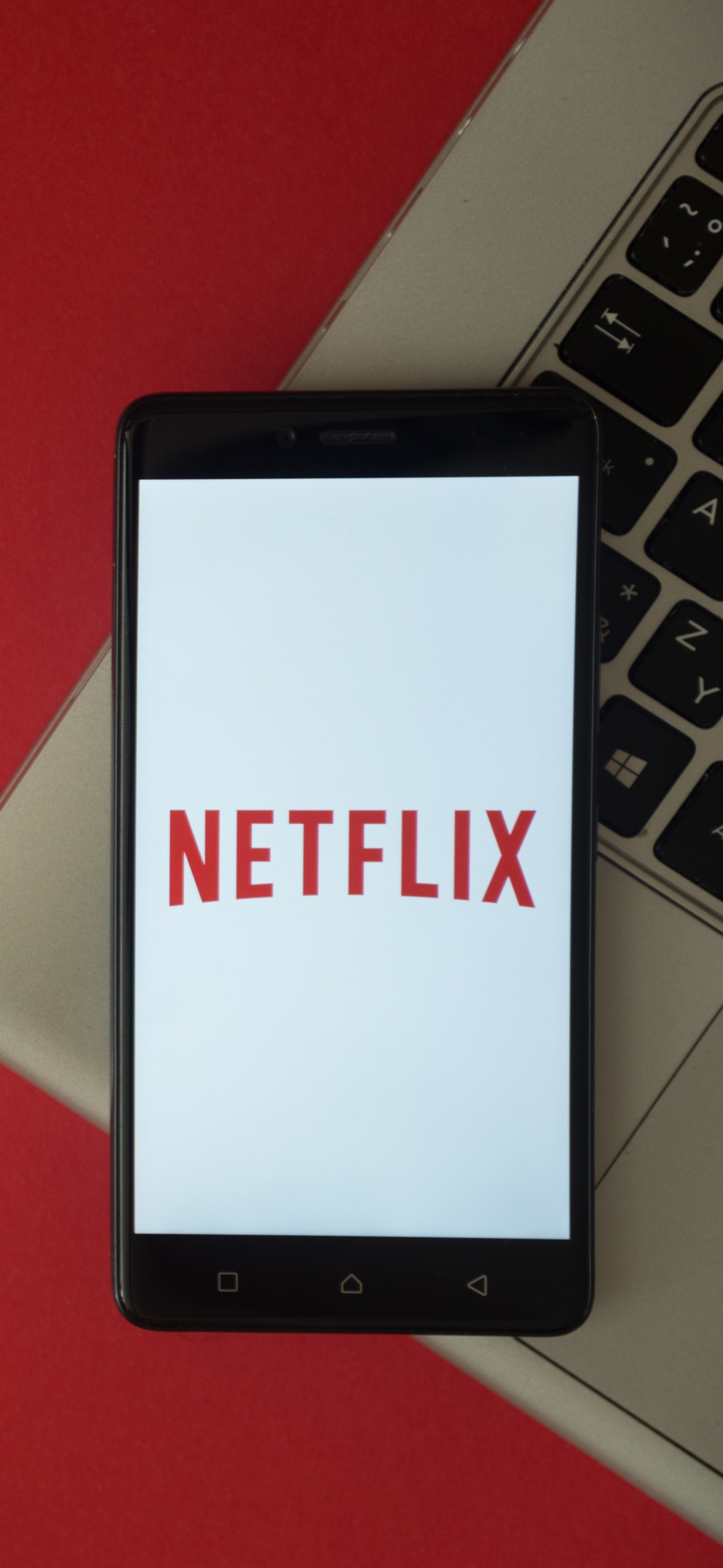 Black Tablet Computer on Red Table. Wallpaper in 1125x2436 Resolution