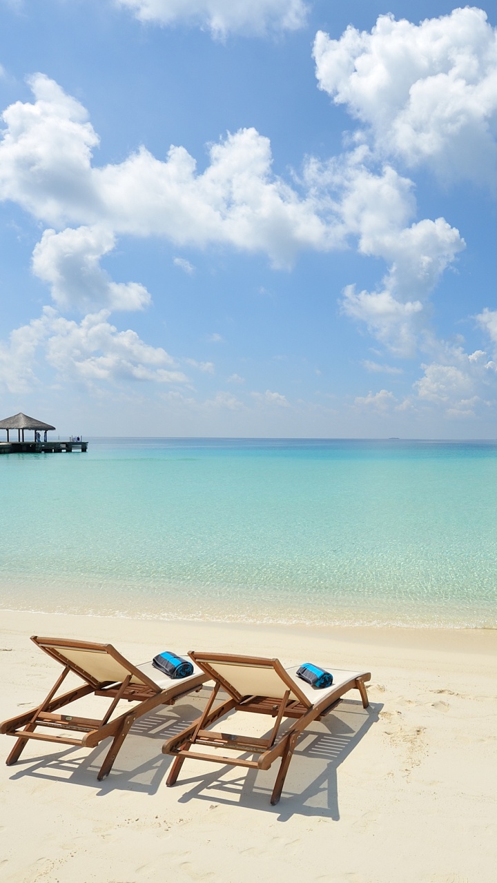 Chaises Longues en Bois Marron Sur la Plage Pendant la Journée. Wallpaper in 720x1280 Resolution