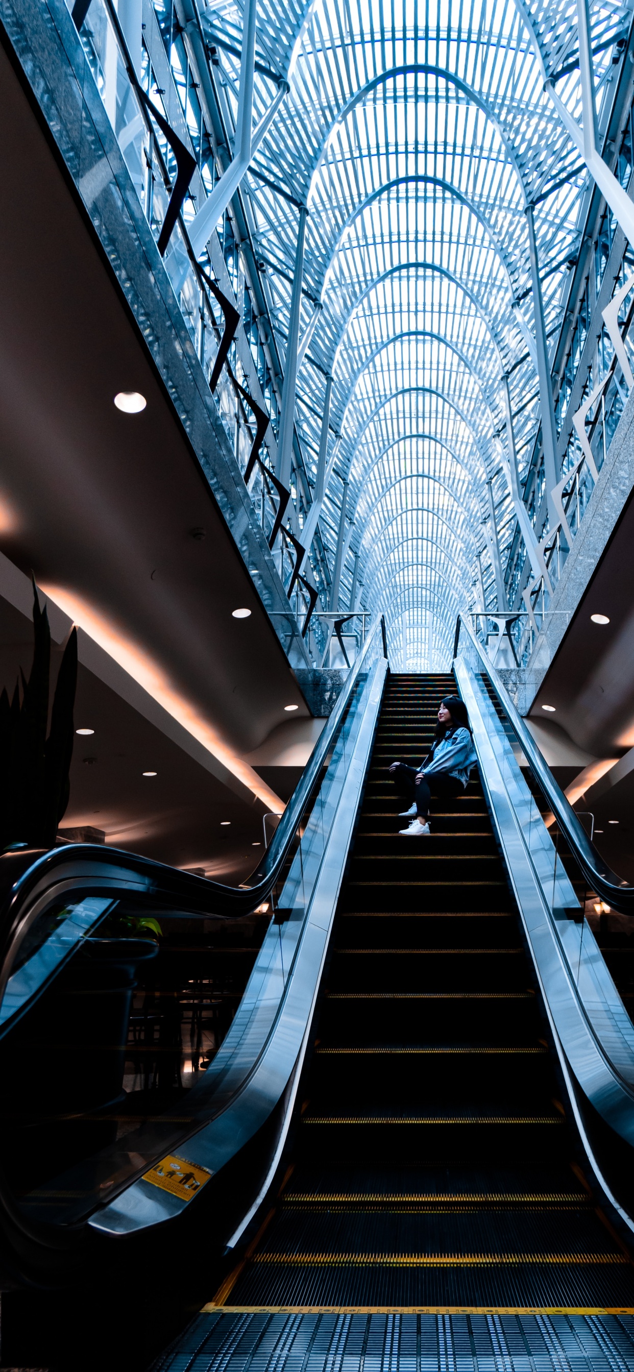 Escalera Mecánica Azul y Negra en un Edificio.. Wallpaper in 1242x2688 Resolution