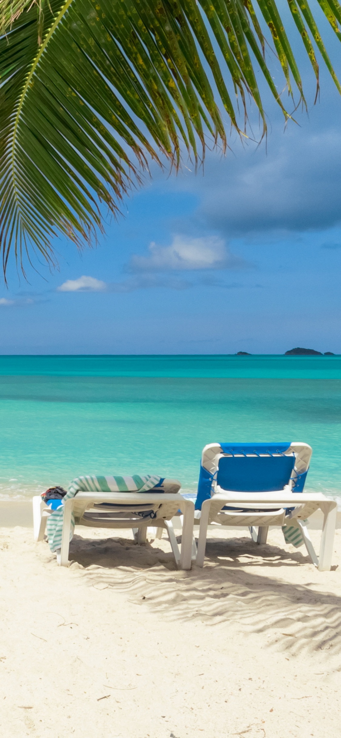 Blue and White Lounge Chair on Beach During Daytime. Wallpaper in 1125x2436 Resolution