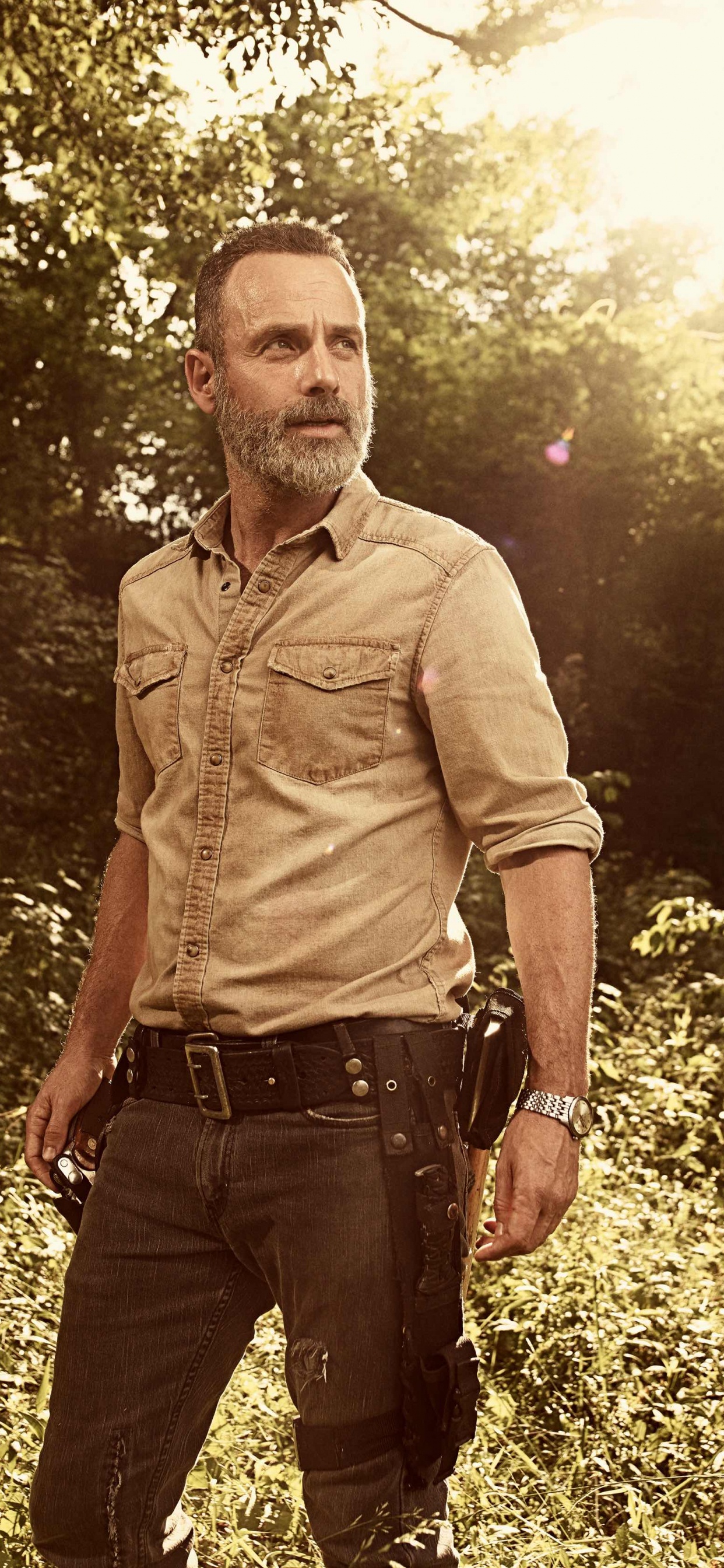 L'homme en Chemise Brune Debout Sur le Terrain D'herbe Verte Pendant la Journée. Wallpaper in 1242x2688 Resolution