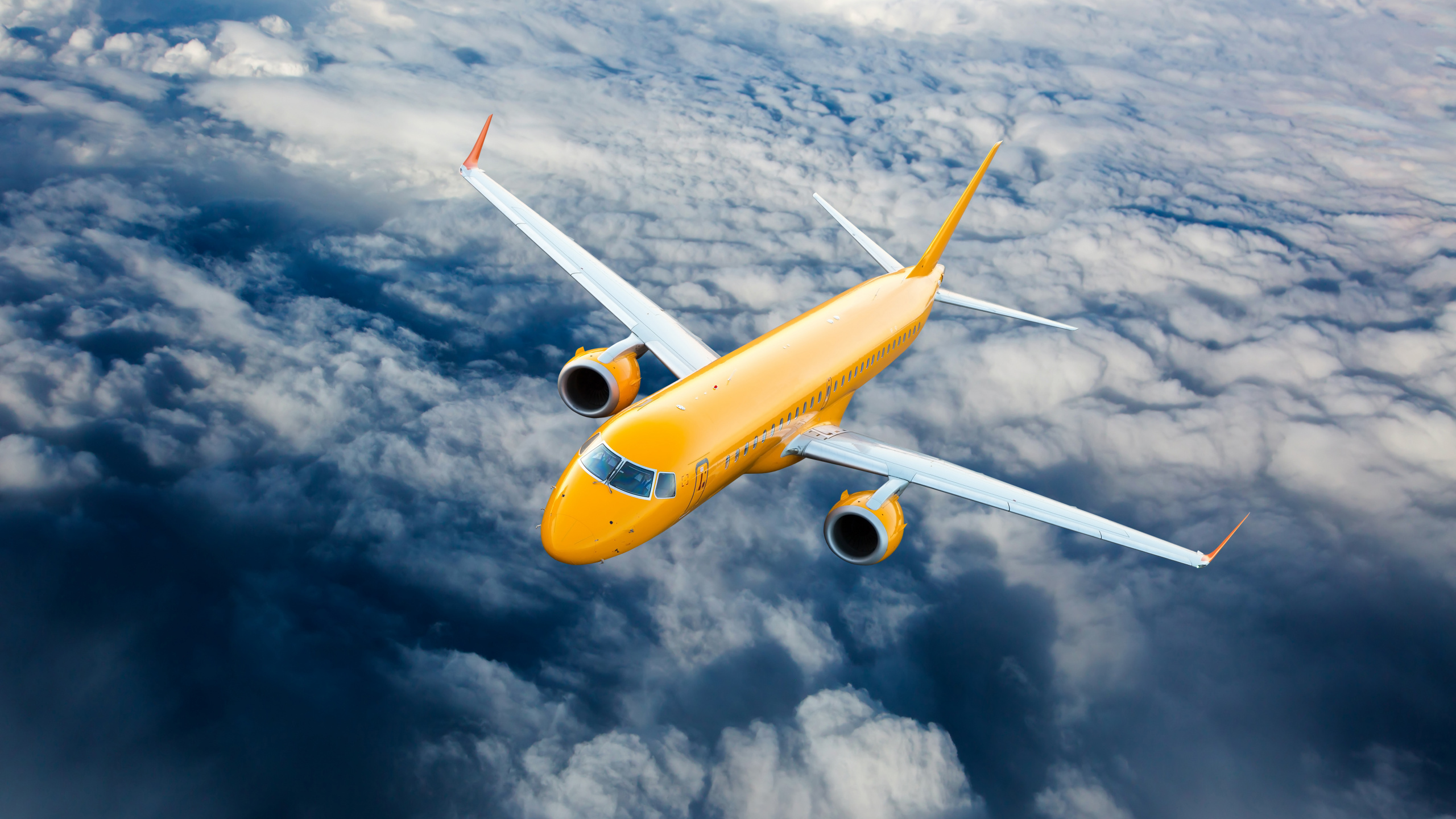 Avión Amarillo y Blanco Volando Bajo Nubes Blancas Durante el Día.. Wallpaper in 2560x1440 Resolution