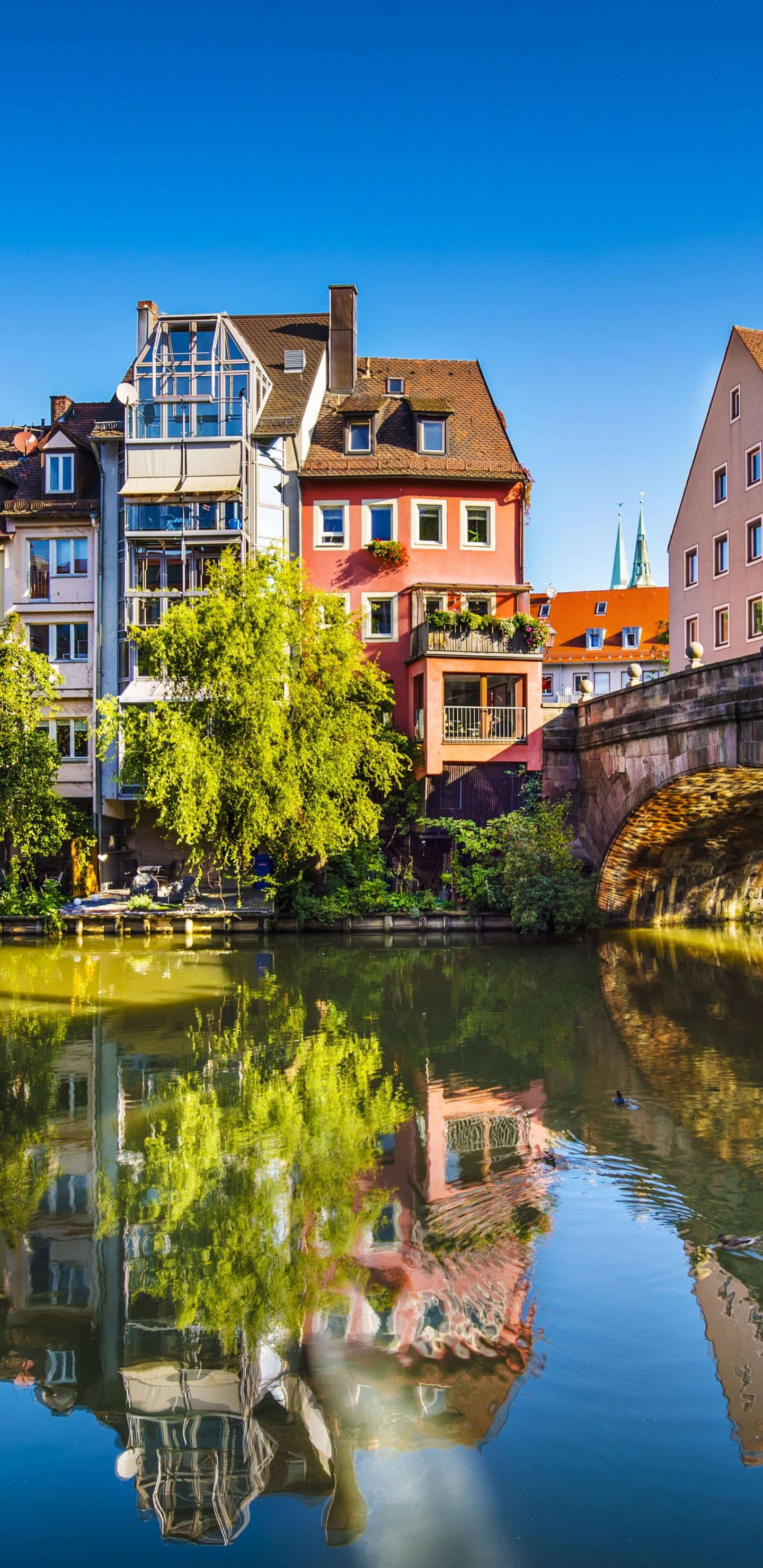 Braunes Betongebäude in Der Nähe Des Flusses Tagsüber. Wallpaper in 1440x2960 Resolution