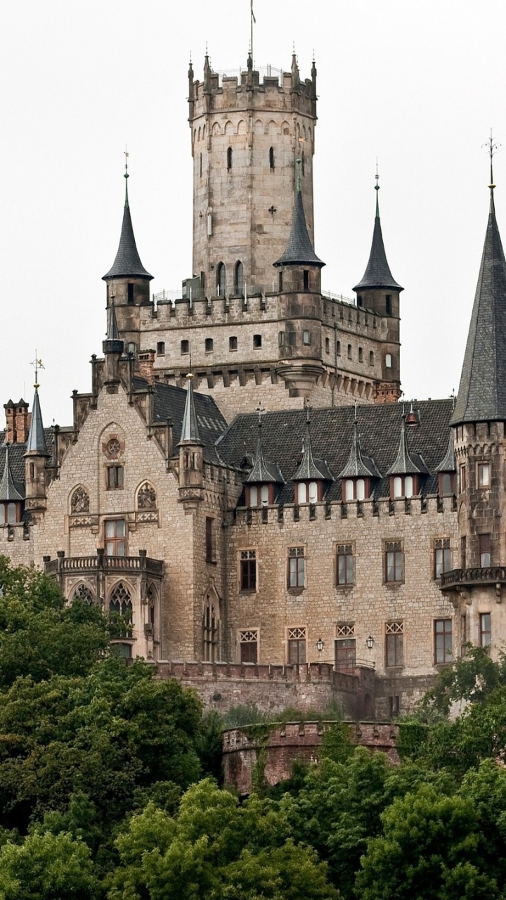 Braunes Und Graues Betonschloss, Tagsüber Von Grünen Bäumen Umgeben. Wallpaper in 720x1280 Resolution