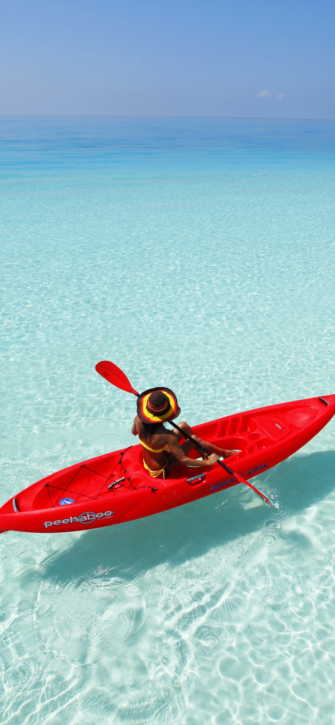 Persona en Kayak Rojo en la Playa de Arena Blanca Durante el Día. Wallpaper in 1125x2436 Resolution