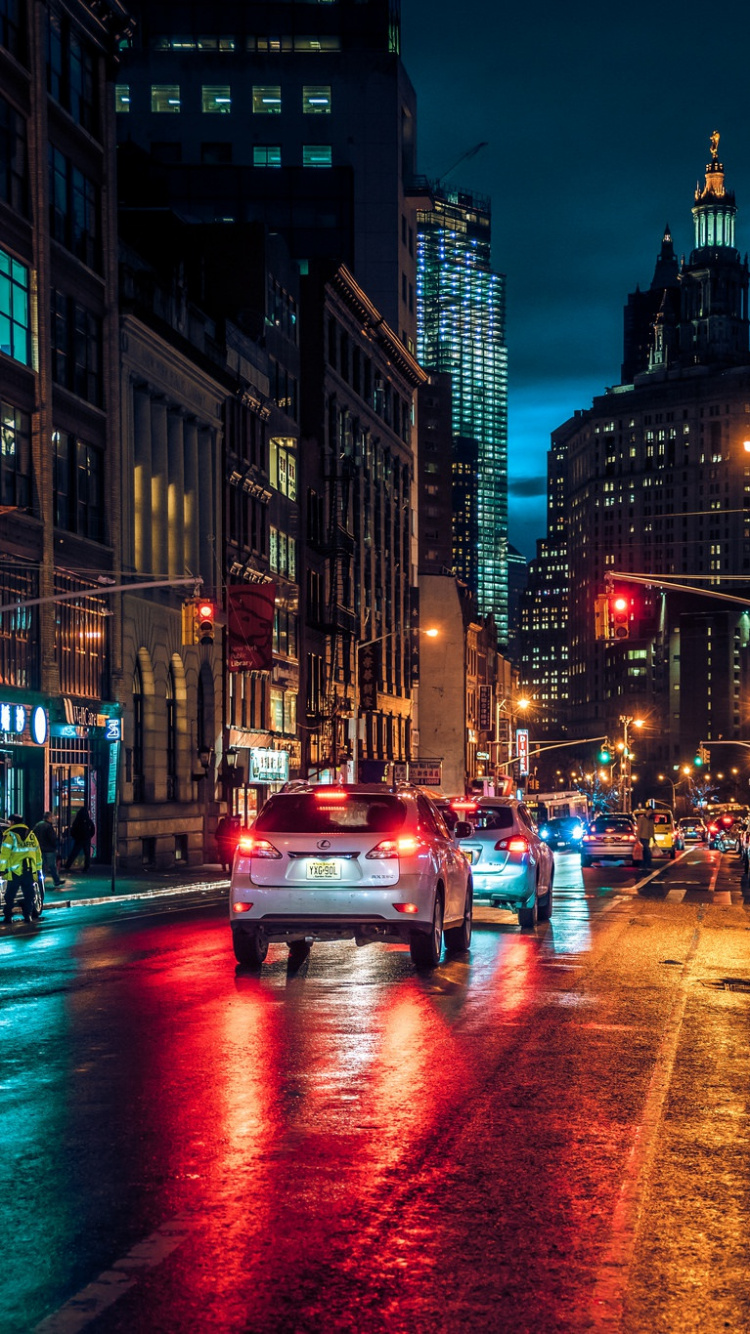 Cars on Road Between High Rise Buildings During Night Time. Wallpaper in 750x1334 Resolution