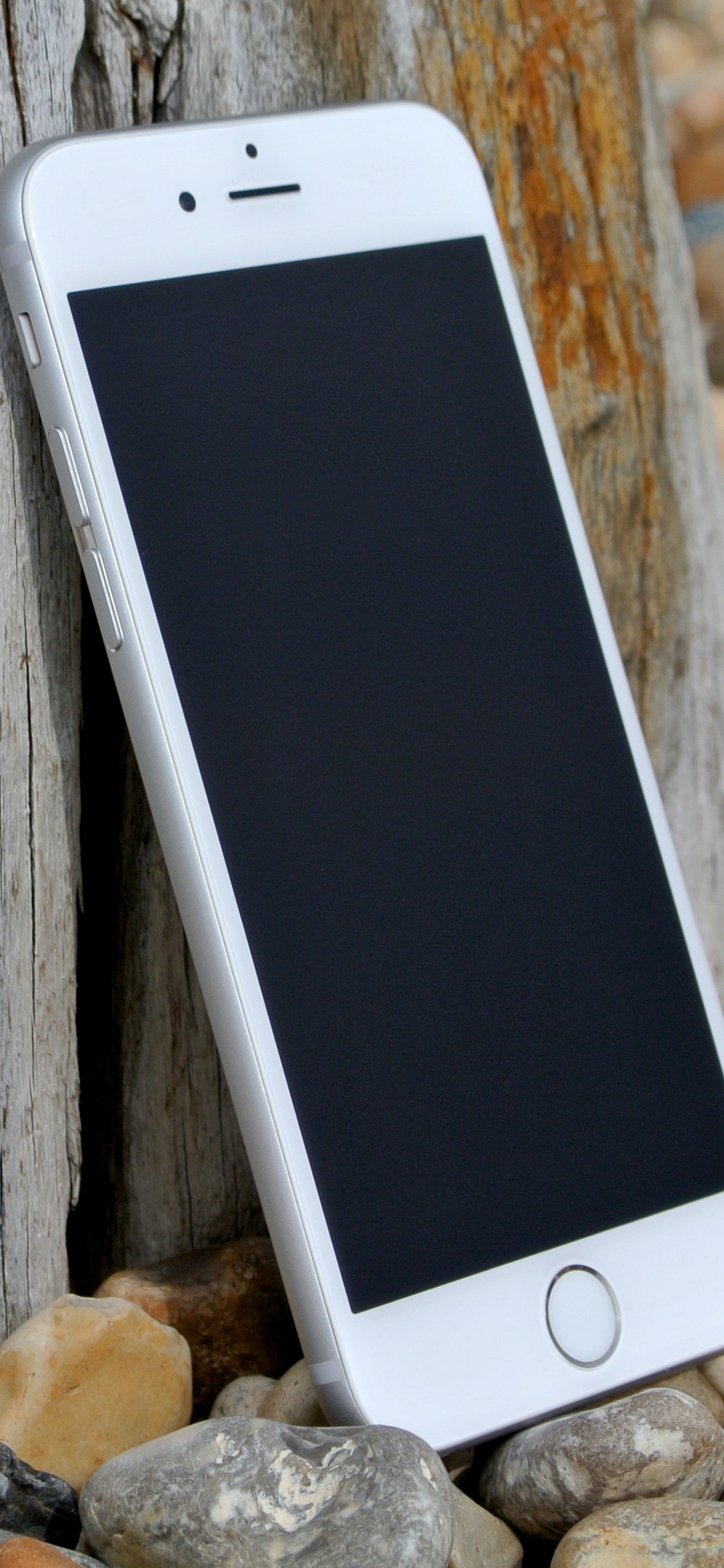 Silbernes Iphone 6 Auf Braunem Holztisch. Wallpaper in 1125x2436 Resolution